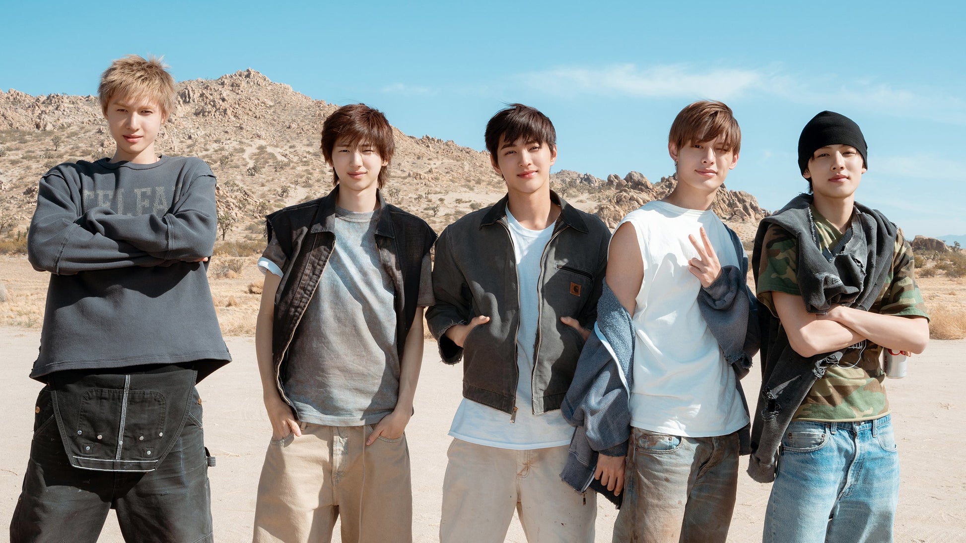 Five individuals standing in a desert landscape with clear blue skies.