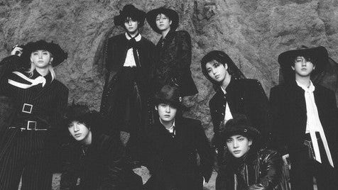 Album cover with a black and white photo of a group of people on a pink background with decorative elements.